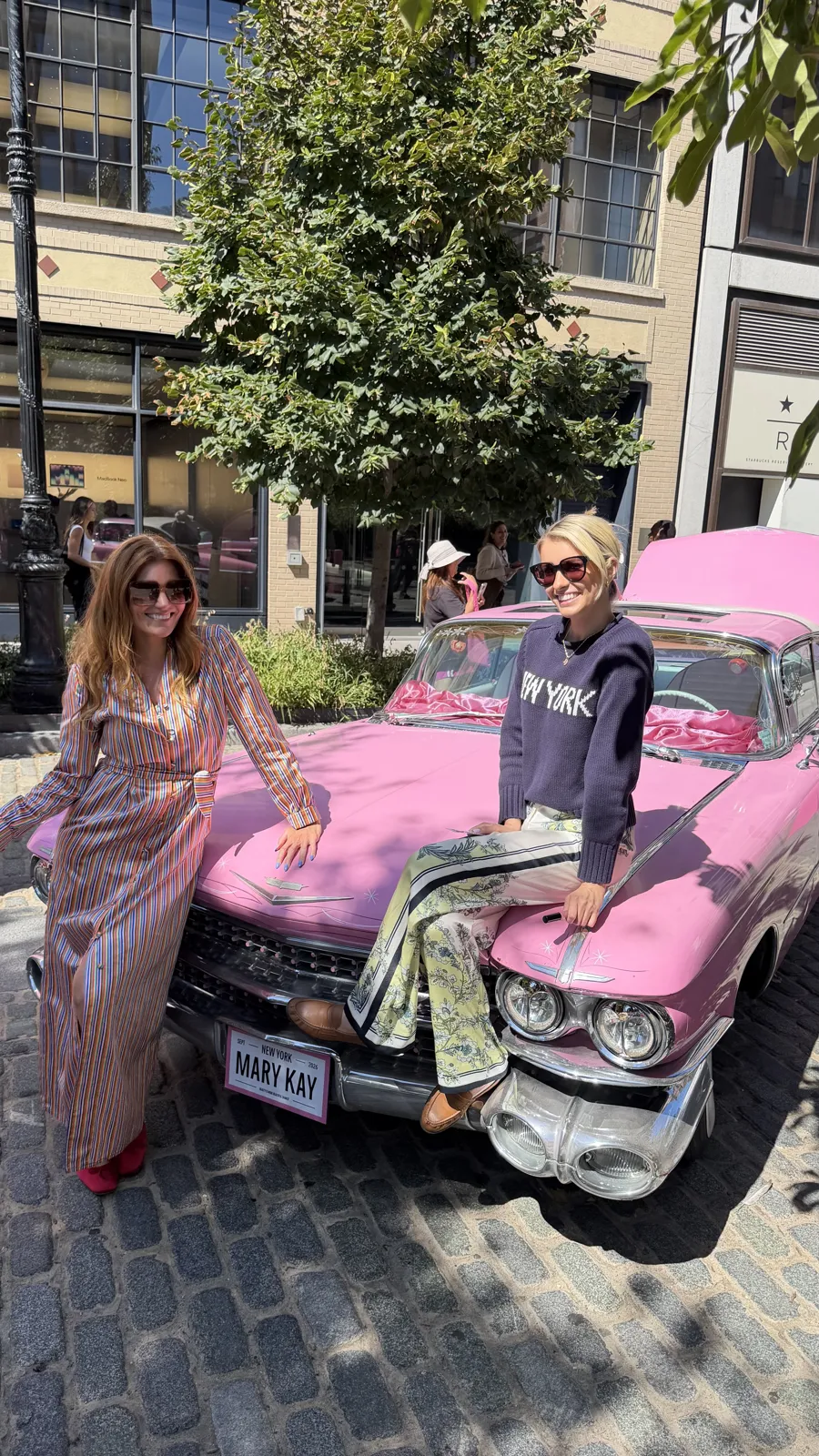 Kristin posing on a pink vintage car at the Mary Kay pop-up