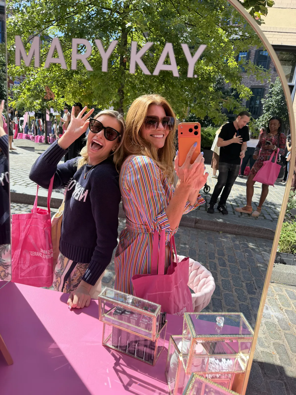 Kristin and Emily at the Mary Kay pop-up sign in SoHo